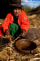 Una mujer prepara el desayuno en la isla de Los Uros ubicada en el interior del Lago Titicaca. 